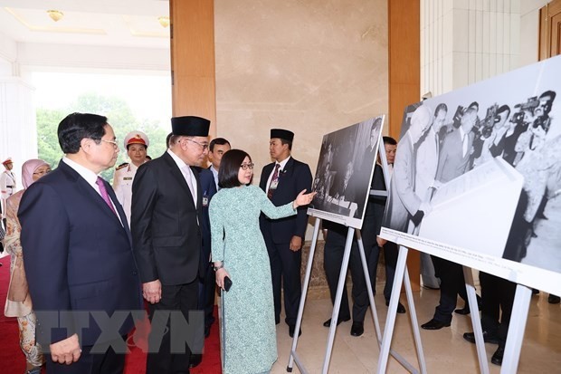 越南政府总理范明正与马来西亚总理安瓦尔·易卜拉欣参观越通社的图片展。