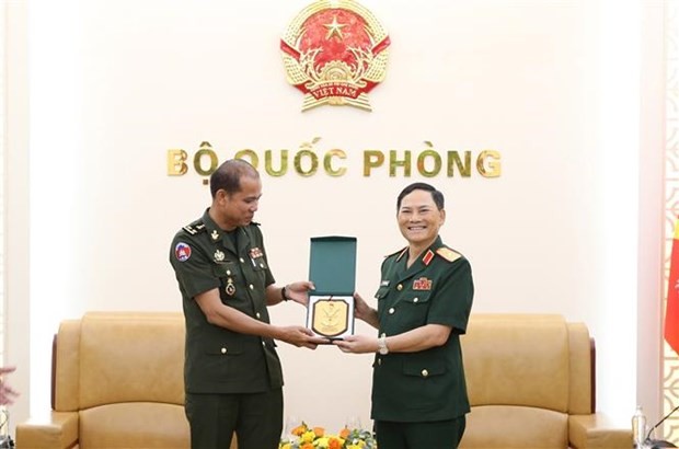 越南人民军副总参谋长范长山少将向柬埔寨王家军总司令部作战局局长嫩巴伦中将赠送纪念品。
