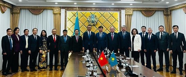 越共中央委员、国会副主席阮克定和哈萨克斯坦领导以及两国代表合影。