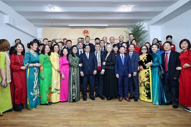 范明正总理和夫人与越南驻罗马尼亚大使馆干部和工作人员以及旅居罗马尼亚越南人社群代表合影。