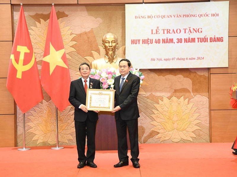 越南国会主席陈青敏向越南国会副主席阮德海同志授予40年党龄纪念章。