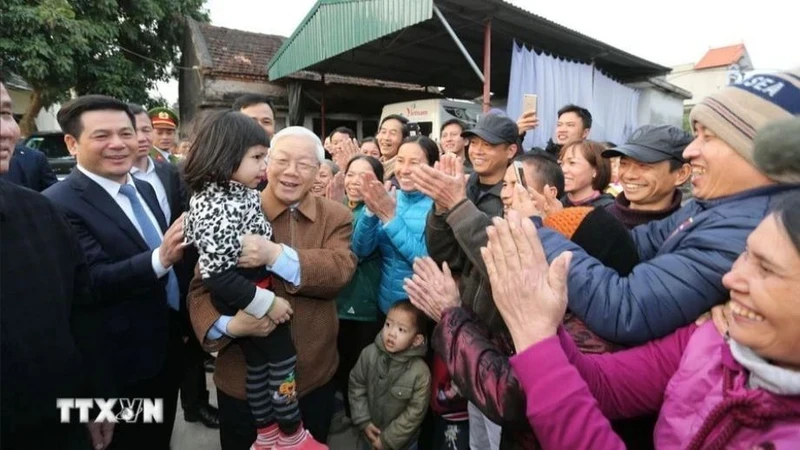 越共中央总书记阮富仲与太平省前海县西安乡人民。（图片来源：越通社）