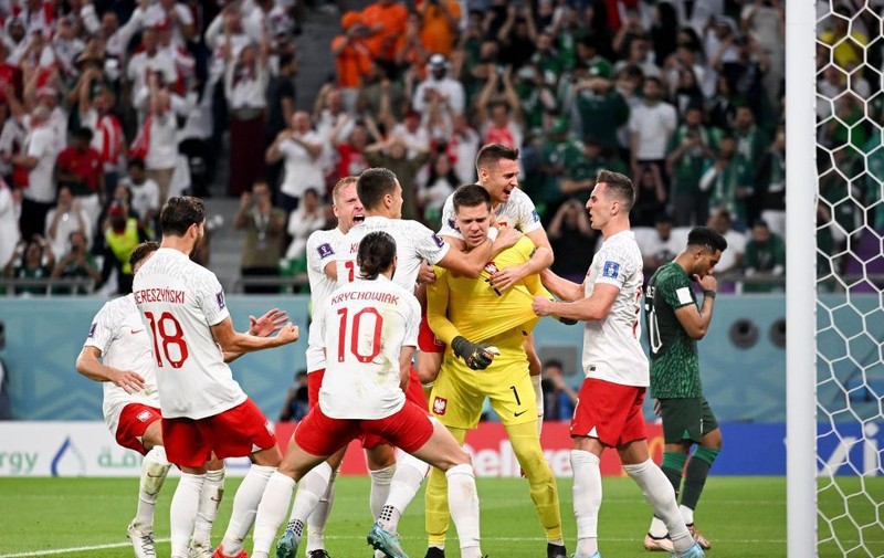 波兰门将扑出点球和补射后与队友庆祝。