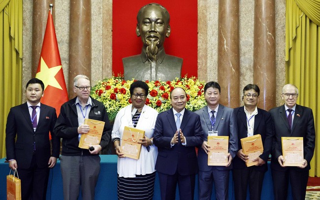 国家主席阮春福向世界和平理事会第22届大会参会代表赠送礼物。（图片来源：越通社）