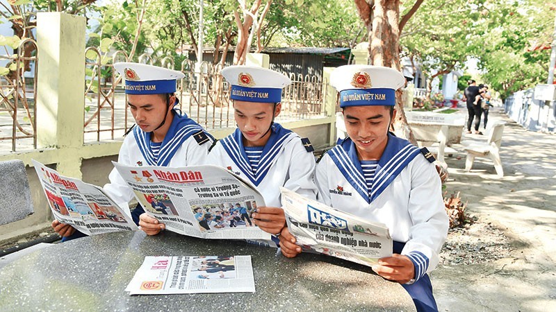 庆和省长沙岛的士兵阅读《人民报》。（登科 摄）