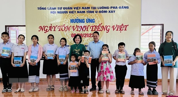 越南驻老挝琅勃拉邦总领事乔氏姮福向旅居老挝和乌多姆塞省越南人社群的贫困学生赠送慰问品。