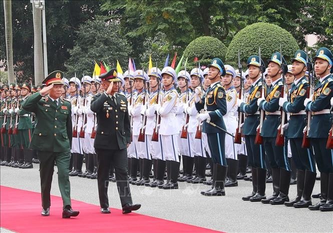 阮新疆上将和西萨瓦特上将检阅越南人民军仪仗队。（图片来源：越通社）