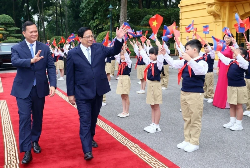 越南政府总理范明正和柬埔寨首相洪玛奈与首都河内儿童。（图片来源：越通社）