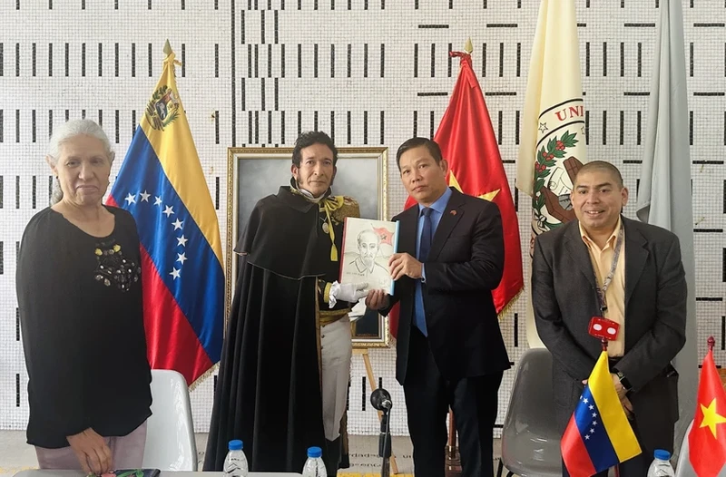 玻利瓦尔大学讲师胡安·加梅兹博士向越南驻委内瑞拉大使武忠美赠送由他自己设计的胡志明主席画。