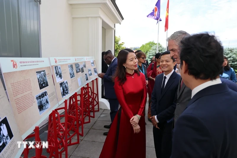 越南外交部副部长阮明姮向国际友人介绍此展上的图片。