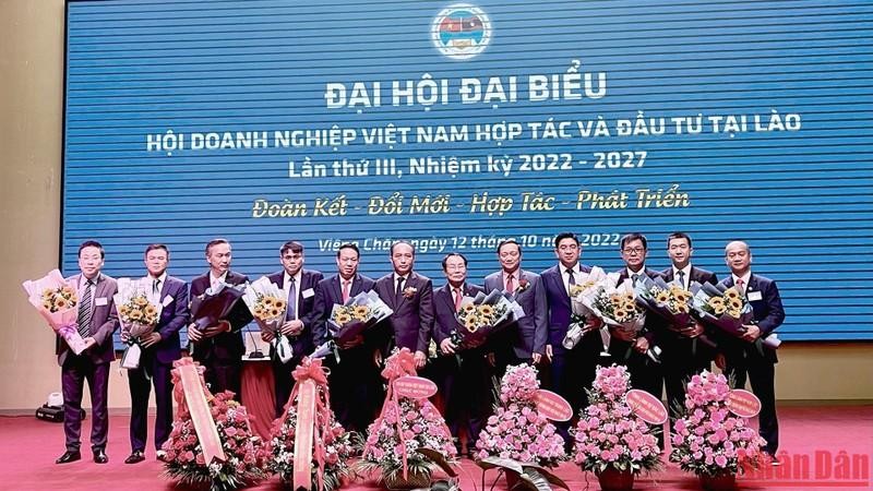 阮伯雄大使和老挝工贸部副部长向第三届（2022-2027年任期）在老挝越南企业协会执委会赠送鲜花。