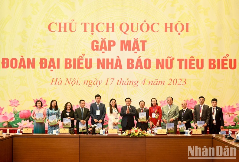 国会主席王廷惠向女新闻工作者赠送纪念品。