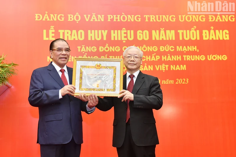 越共中央总书记阮富仲向原越共中央总书记农德孟授予60年党龄纪念章。