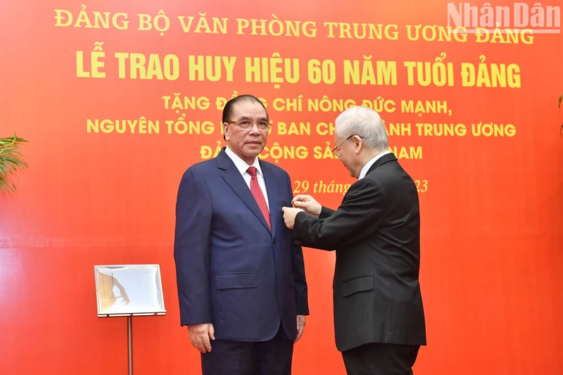 越共中央总书记阮富仲向农德孟同志颁发60年党龄纪念章。