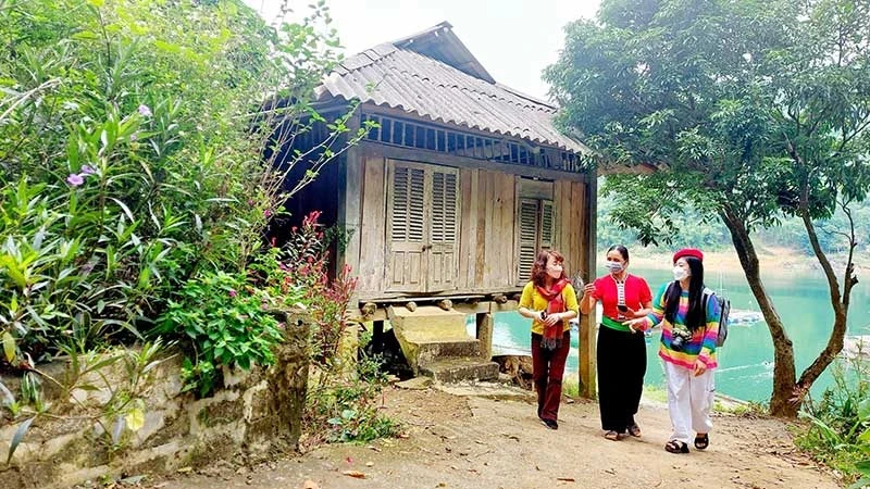 当地人民向游客介绍和平省陀北县石卑社区旅游村。