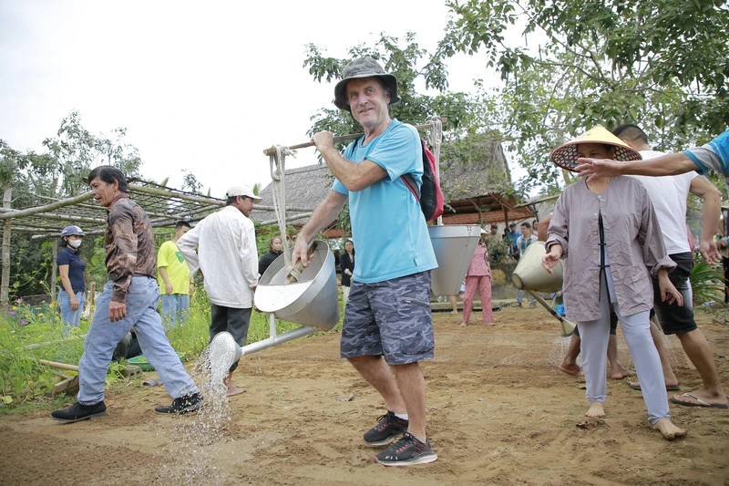 外国游客在茶桂蔬菜村体验农耕乐。（图片来源：sggp.org.vn）
