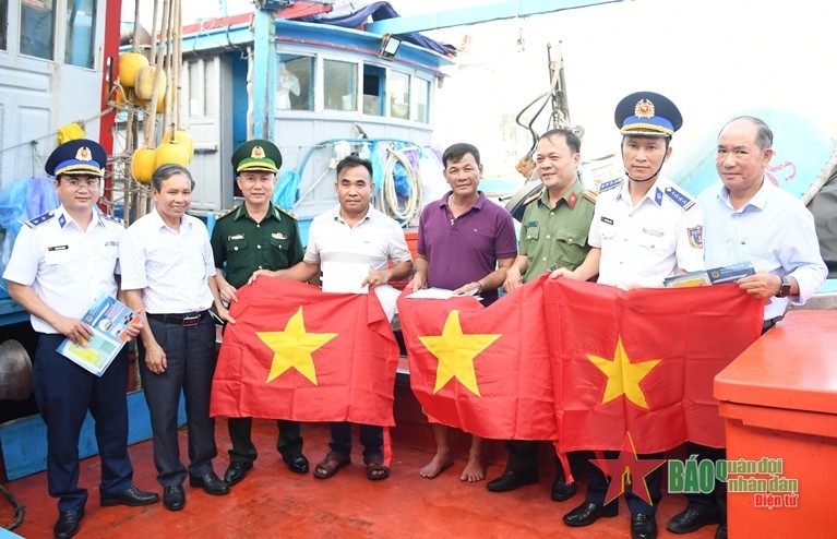 海警第二区向普光乡渔船船主赠送国旗和礼物。（图片来源：canhsatbien.vn）