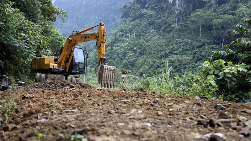 林平县建设投资项目管理委员会动用挖掘机平整道路上的侵蚀点。