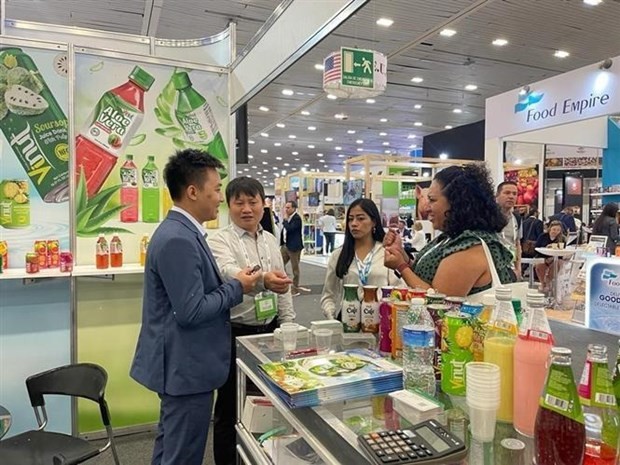 越南驻墨西哥经济商务处代表向参观者介绍VINUT产品。