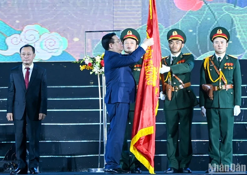 国会主席王廷惠把勋章佩戴在传统旗帜上。