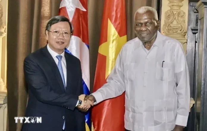 古巴全国人民政权代表大会主席拉索与越南驻古巴新任大使黎光龙握手。