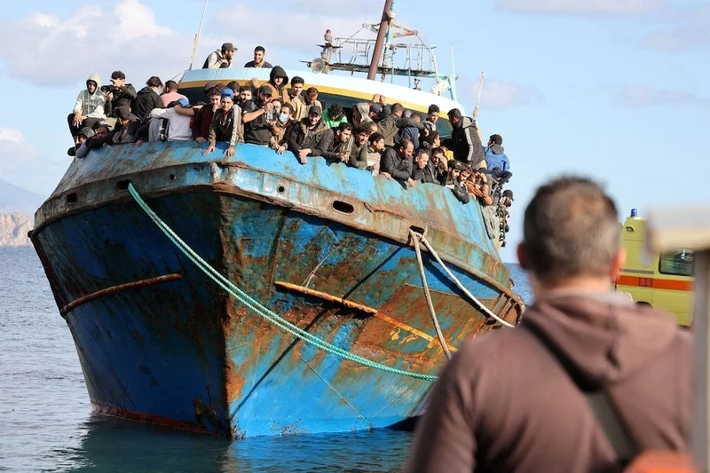 2022年11月22日，在希腊克里特岛海岸的救援行动中，移民站在帕莱奥霍拉港的一艘渔船上。图片来源：路透社