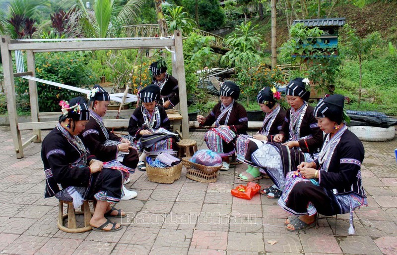 莱州省三唐县卢族妇女缝制土锦传统服饰。