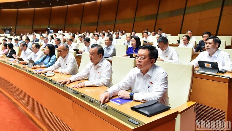 越南国会代表按下表决器表决通过关于2013年《宪法》若干条款修改补充的决议。