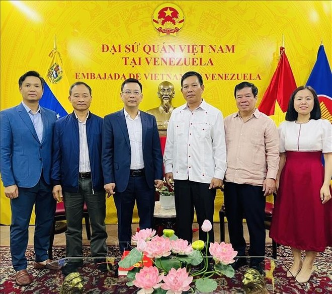 越南友好组织联合会代表团与越南驻委内瑞拉大使馆代表合影。
