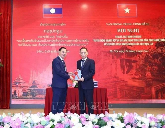 黎怀忠同志向通沙立·蒙诺梅同志赠送《越共中央办公厅和老挝人民革命党中央办公厅合作关系传统》一书。（图片来源：越通社）