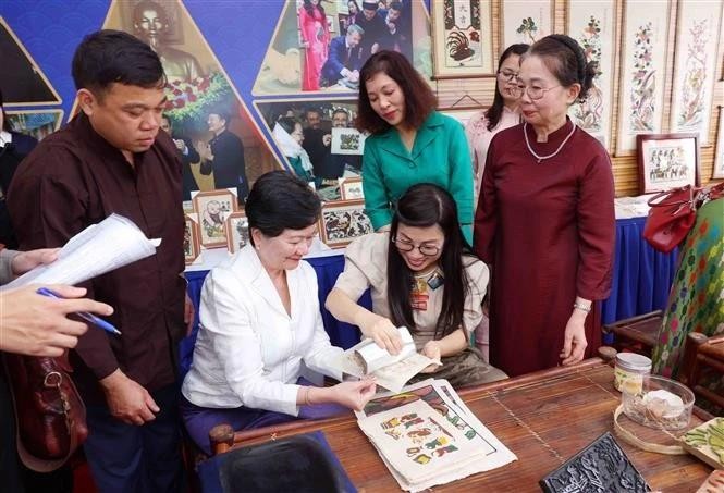 越南政府总理夫人同河内市东盟妇女小组体验东湖民间画印制。 （图片来源：越通社）