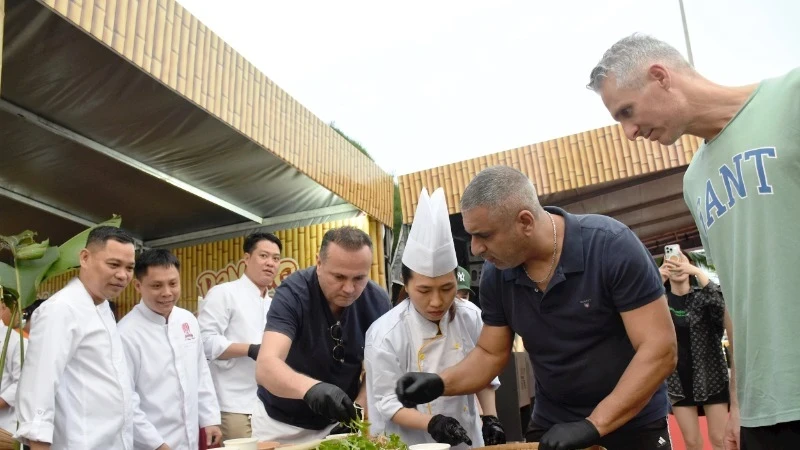 国际游客在2025岘港美食之旅节上体验制作鱼沙拉。