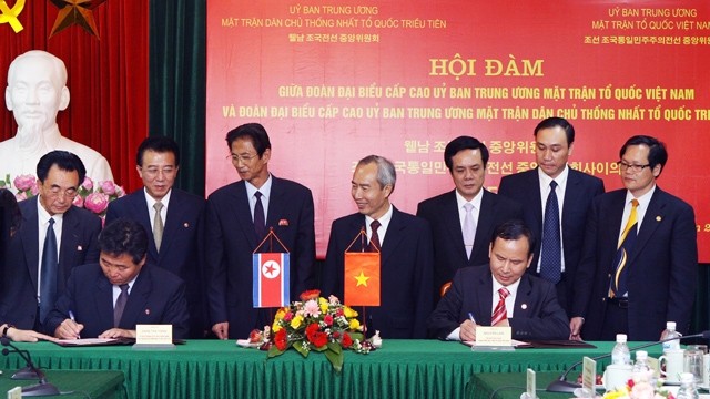 越南祖国阵线主席黄胆与金完洙同志会谈后出席双方签署有关合作文件仪式。 (Photo: 图：越通社)
