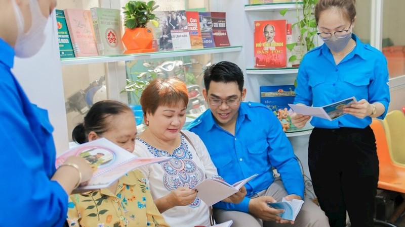 平盛郡青年向观众介绍有关胡志明主席的书籍。（图片来源：hcmcpv.org.vn）