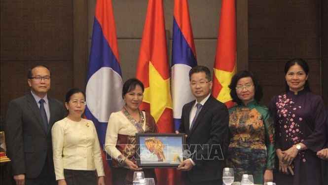 岘港市领导向老挝妇女联合会主席因塔万·乔本潘女士赠送纪念品。（图片来源：越通社）