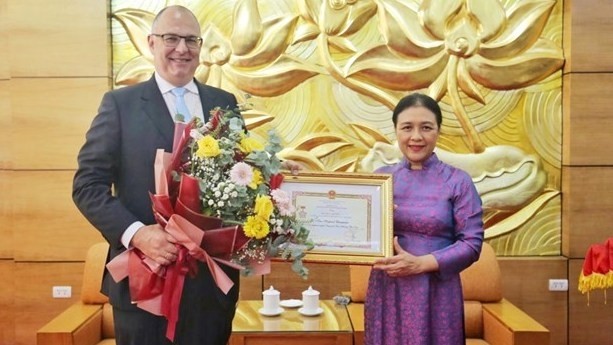 阮芳娥女士向金•霍伦德•克里斯滕森大使授予“致力于各民族和平友谊”纪念章。（图片来源：时代报）