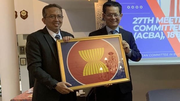 马来西亚大使努尔·阿兹曼·阿都拉欣向越南大使杨国青转交东盟驻阿根廷委员会轮值主席。（图片来源：越通社）