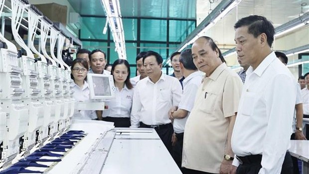阮春福主席造访海防市高效的纺织服装经营生产模式。（图片来源：越通社）