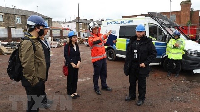 越南驻英国副大使苏明秋（左三）与大曼彻斯特地区警方交谈。（图片来源：越通社）
