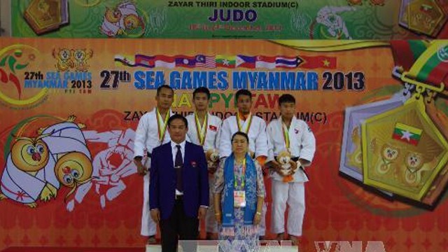 越南柔道选手黄一统（左二）在颁奖台上。（图片来源：越通社）