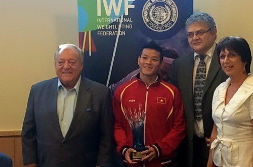 国际举重联合会主席塔马斯•阿贾恩（左）给石金俊颁发2014年世界青年举重锦标赛的最佳运动员奖项。（图片来源：越南快讯报网）