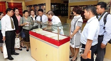 老挝《人民报》社干部代表团参观越南《人民报》传统屋。