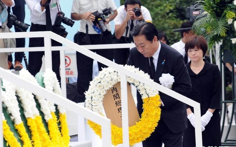 8月9日，在日本长崎和平公园，日本首相野田佳彦（前）向原子弹轰炸遇难者纪念碑敬献花圈。