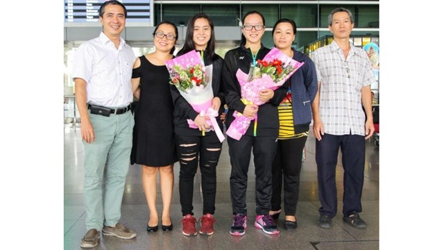 黎美贤和阮黎庆在机场与家属合影留念。（图片来源：体育报）