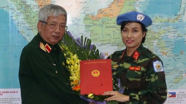 阮志咏上将向杜氏姮娥少校颁发决定书。