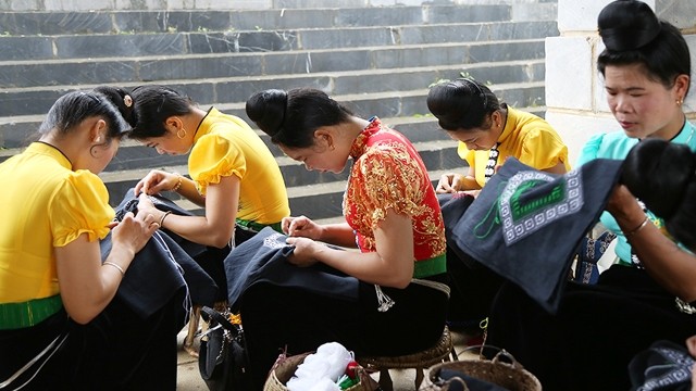 图为：越南黑泰族妇女编织头上戴的“标”头巾。