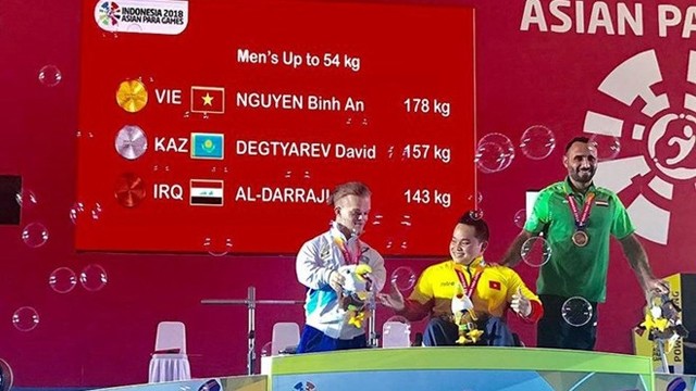 举重运动员阮平安（中）为越南队夺下第二枚金牌。（图片来源：体育报）