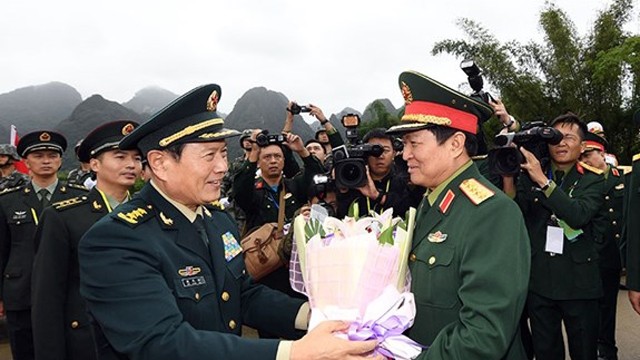 魏凤和上将送花欢迎吴春历大将一行的到来。