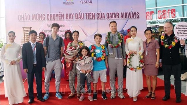 岘港市旅游局领导向乘坐卡塔尔多哈至岘港市首次航班的乘客赠送鲜花。（图片来源：越通社）
