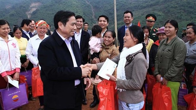 越共中央组织部部长范明正向清化省芒勒县群众赠送慰问品和慰问金。（图片来源：越通社）